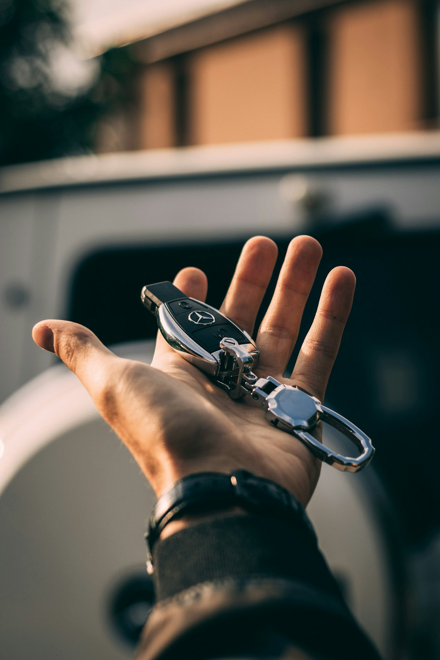 A hand holding a Mercedes-Benz key fob